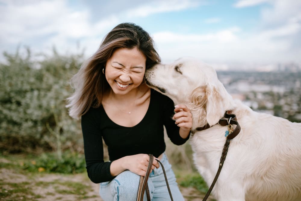 Happy resident with dog at Coralaire Apartments in Sacramento, California
