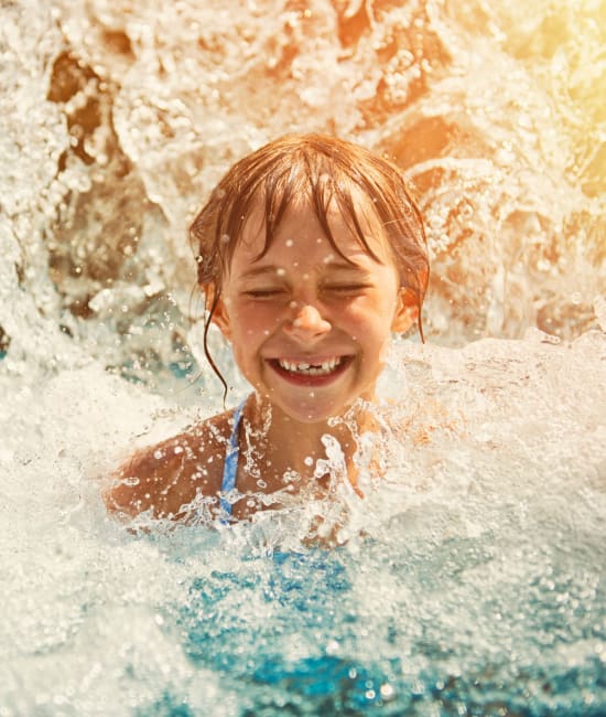 Resident swimming in pool of Coralaire Apartments in Sacramento, California
