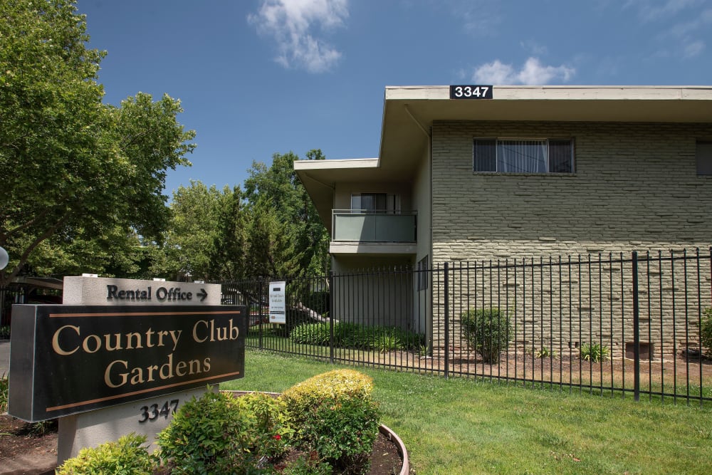 Monument sign, building and grassy area at Country Club Gardens in Sacramento, California